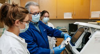 Photo of 3 people looking at data in our Forensic Science Training Center