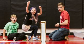 Photo of youth children and an ONU student working on a vehicle ramp