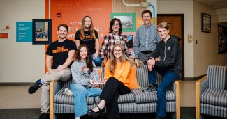 Group photo of the entire ONU ethics team and the instructor posed around/on a couch