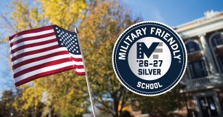 US Flag blowing in the air with a military friendly school badge next to it