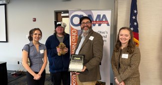 Group of 4 holding an award 