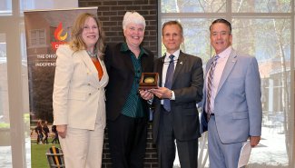 Pam Hershberger posing with a group of 4, one being the ONU President Baumann