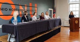 Women in leadership panelist and President Baumann behind the podium