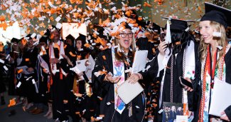 ONU graduation students excited with confetti in the air.