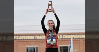 Avery holding up the national title trophy in high jump