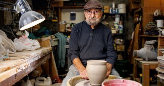 Professor Emeritus Bruce Chesser working with ceramic clay in an art studio.
