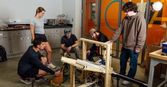 Engineering students and faculty working together in a classroom or lab setting.