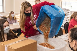A student volunteers in Feb. 2022 at a God Always Provides meal packing event at Ohio Northern University.