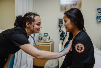 Ohio Northern University nursing students practicing stethoscope technique.