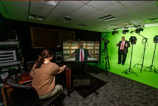 Photo of instructor in front of green screen