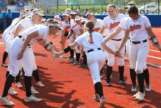 Ohio Northern University softball players welcoming a teammate to the field.