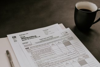 Coffee cup and tax forms by Kelly Sikkema for Unsplash