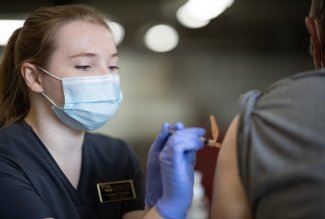 An Ohio Northern University pharmacy student administering a COVI-19 vaccine.