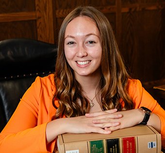 Photo of Sunny with her hands on crossed on a stack of books